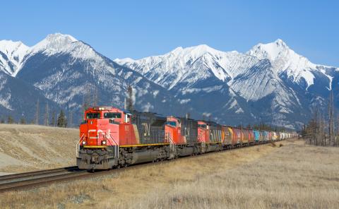 Red train with a mountain range in the background